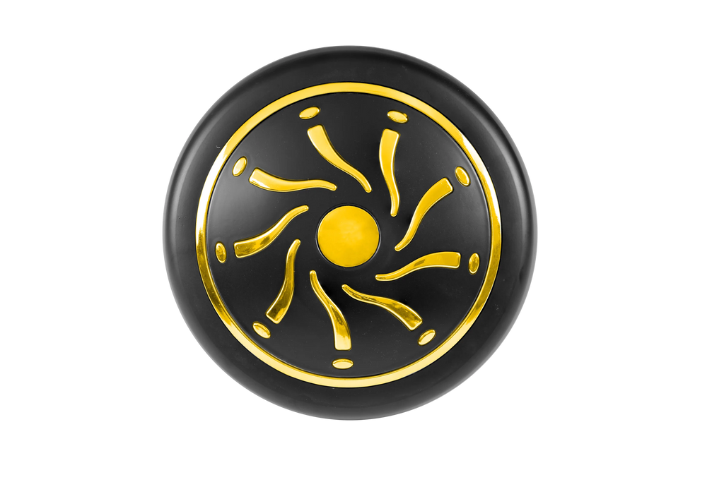 Black circular object with gold sun-like design on a white background